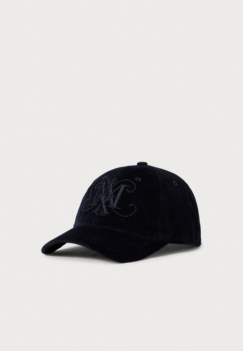 Svart kordfløyels baseballcap med brodert logo av overlappende bokstaver foran, buet skjerm og ventilasjonsluftehull på toppen.