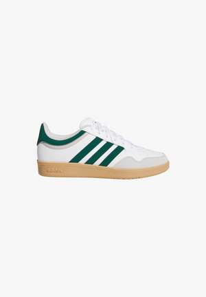 Weißer Sneaker mit niedrigem Schaft, grünen Streifen, beiger Sohle und Schnürdesign, seitlich auf weißem Hintergrund dargestellt.