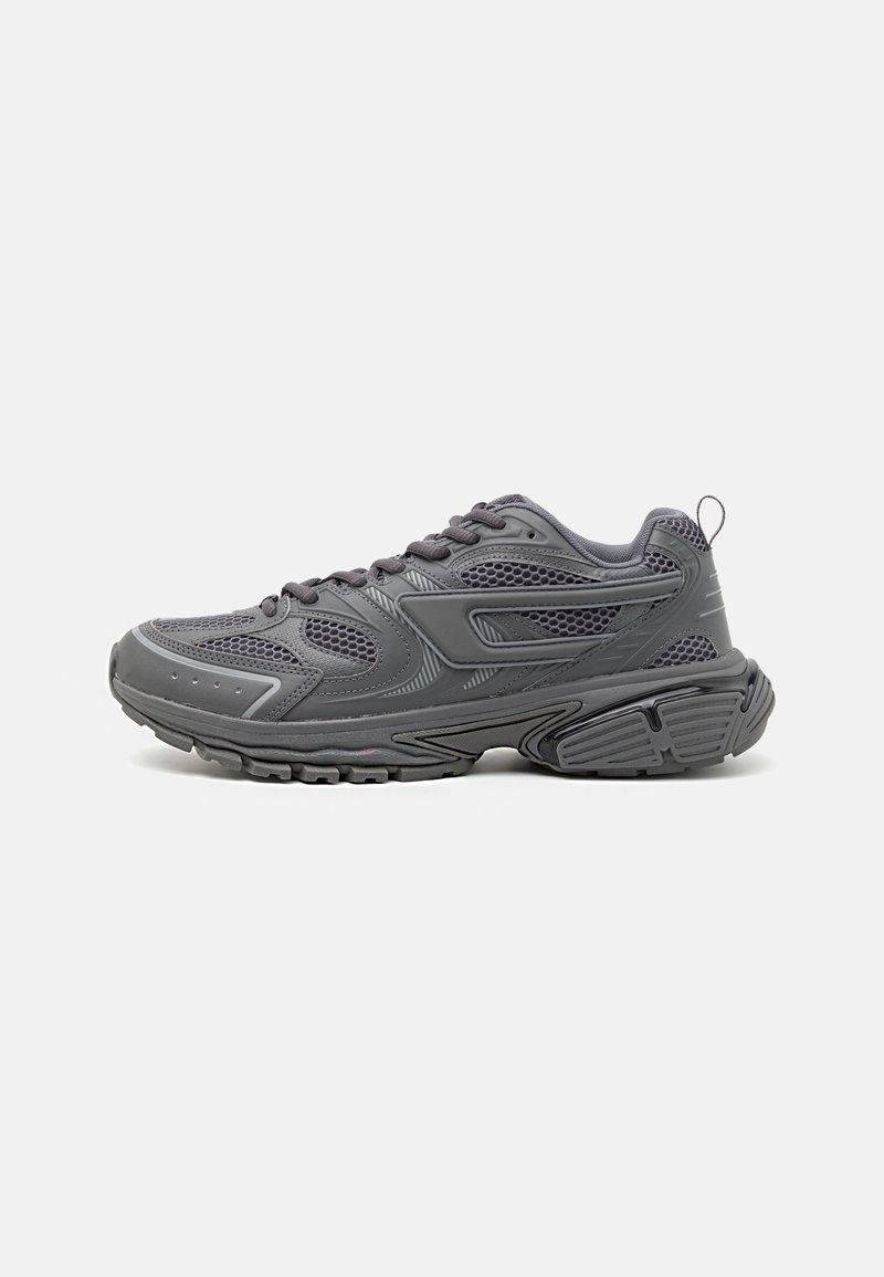 Scarpe sportive grigie con pannelli in rete, rivestimenti testurizzati e suola spessa. Presentano una punta arrotondata e un design con lacci, con linguetta per facilitare l'indosso.