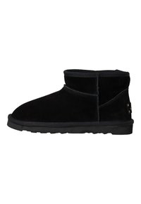 Botines de ante negro con un diseño de perfil bajo, puntera redondeada y suela de goma texturizada. Presentan una costura cosida y un detalle de marca sutil.