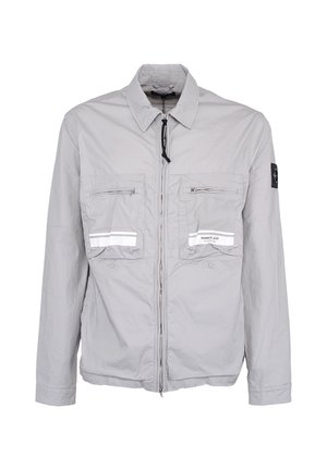 Jasnoszara kurtka na zamek błyskawiczny z dwoma zapinanymi na zamek kieszeniami na piersi, odblaskowymi paskami i czarną łatą na lewym rękawie.