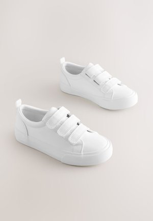 Valkoiset tennarit, joissa on kolme tarranauhaa, valmistettu sileästä materiaalista, pyöreällä kärjellä ja kuvioidulla kumipohjalla.