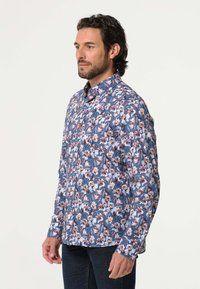Langarmshirt met een blauw bloemmotief met roze en witte bloemen. Gemaakt van lichtgewicht stof, het heeft een button-down kraag en een slim fit.