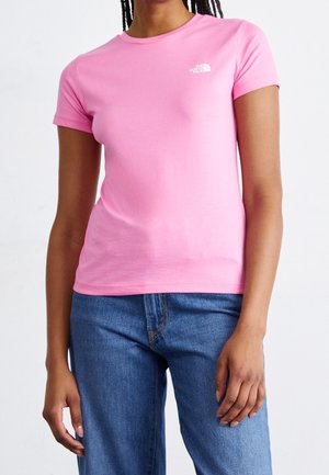 Pink short-sleeve T-shirt made of cotton, featuring a crew neck and a small white logo on the chest. Paired with blue denim jeans.