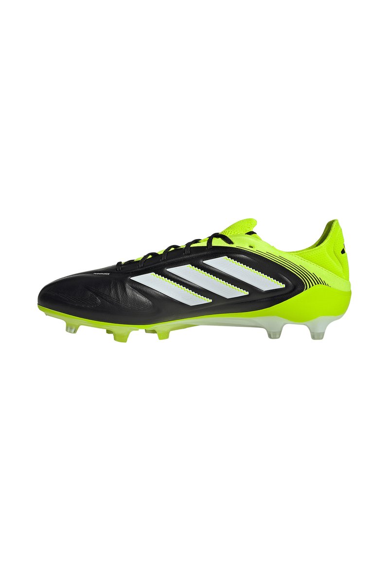 Crampons de football noirs et vert néon avec un dessus synthétique, trois accents rayés blancs, et des crampons moulés transparents pour une meilleure traction.