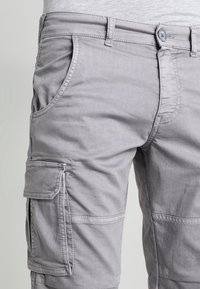 Harmaat cargo-shorts, joissa on useita taskuja, nappikiinnitys ja sileä, kevyt kangas.