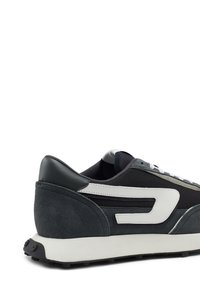 Baskets de sport avec une tige en mesh noir, des accents en daim gris et un logo blanc. Semelle extérieure en caoutchouc avec une bande de roulement texturée pour une meilleure adhérence.