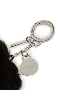 Portachiavi con pompon in pelliccia nera e hardware metallico color argento, dotato di un'etichetta circolare in rilievo con la scritta "KARL LAGERFELD." Include un gancio per il fissaggio.