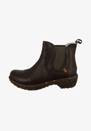 Stivale alla caviglia in pelle marrone con pannelli elastici laterali, suola texturizzata e un tassello per il tiraggio. Caratterizzato da una punta arrotondata e una suola robusta e spessa.