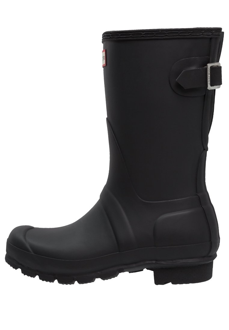 Bota de lluvia de caucho negro con una superficie texturada, puntera redonda y un acento de correa en el lateral. Presenta una suela plana duradera para mayor tracción.