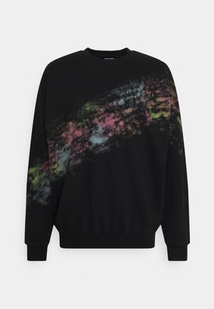 Sweat-shirt noir à manches longues avec poignets et bas côtelés, présentant un motif floral multicolore délavé en diagonale sur le devant et la manche gauche.