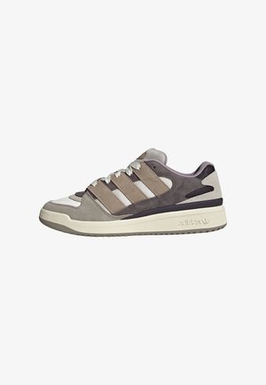 Zapatilla Adidas de corte bajo en beige, gris y blanco, con paneles de ante y malla, cordones blancos, tres franjas laterales y una suela blanca gruesa.