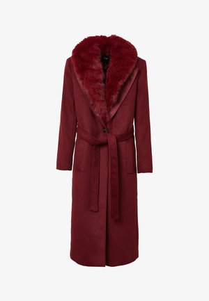 Long manteau bordeaux avec un col en fausse fourrure, en tissu en laine texturé, ceinture à nouer à l'avant et poches latérales. Fermeture à bouton unique à l'avant.