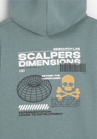 Sudadera con capucha en azul verdoso apagado, con texto y diseños gráficos blancos que incluyen una calavera y un globo, impresa en suave tela de algodón.