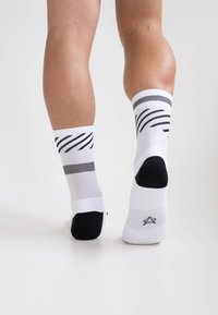 Weiße Sportsocken mit schwarzen und grauen gestreiften Mustern, verstärkter schwarzer Zehen- und Fersenbereich, weiches Material, passgenauer Schnitt für Komfort.