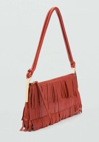 Sac à main en cuir rouge avec des franges verticales, une bandoulière nouée et des détails en métal doré. Compact, avec une fermeture éclair et une surface texturée.