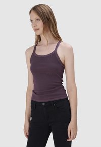 Paarse geribde tanktop met dunne schouderbandjes en een ronde halslijn, gecombineerd met zwarte jeans. Glad textuur, aansluitend ontwerp.