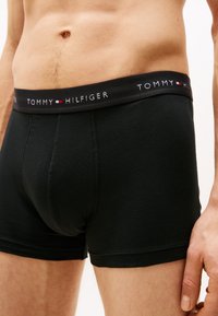 Fekete pamut boxer alsónadrág egyszínű kialakítással, fekete derékpánttal, fehér "TOMMY HILFIGER" márkázással. Normál szabás.