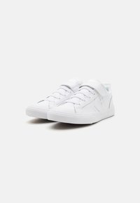 Baskets blanches avec un dessus en synthétique lisse, un design à lacets, une sangle en velcro, une semelle en caoutchouc et de légers accents bleus sur les côtés.