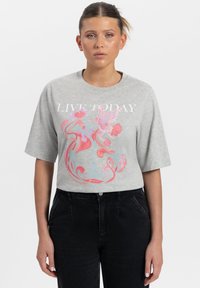 Grijze T-shirt met korte mouwen, voorzien van een grote roze en blauwe bloemenschildering met de tekst "LEEF VANDAAG" in witte letters. Zachte katoenstof.