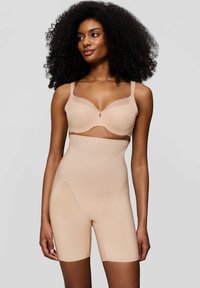 La shapewear beige presenta un design senza cuciture con una texture a coste. Il reggiseno ha coppe morbide e spalline regolabili, offrendo una silhouette liscia.