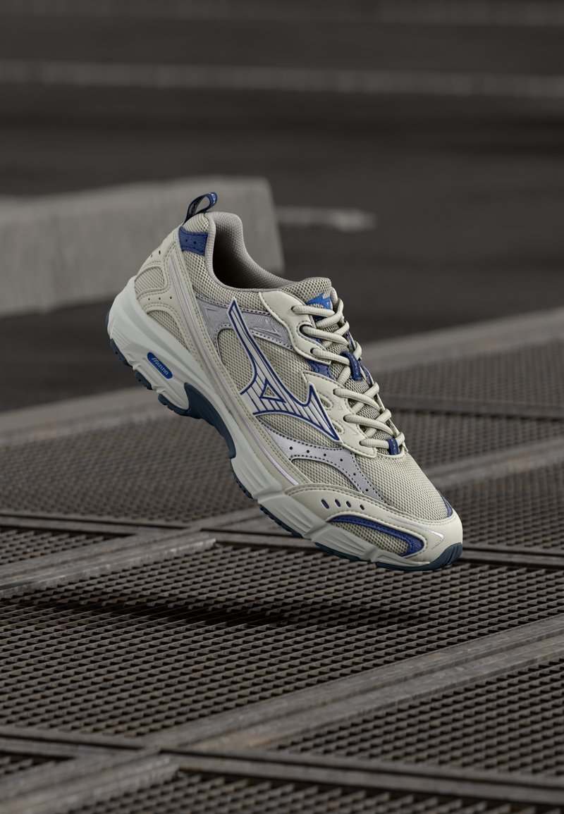 Light gray athletic sneaker with blue accents, mesh upper, rounded toe, and cushioned sole. Features lace-up design and logo detail.