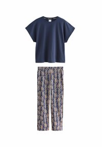 Námořnicky modré bavlněné tričko s krátkymi rukávmi spárované s pyžamovými nohavicami s motívmi slonov v béžovej a zlatej farbe na tmavom pozadí.