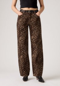 Leopardprint wijde broek in bruin en tan, met voorzakken, een riem en een zachte textuur. Gemaakt voor een ontspannen pasvorm.