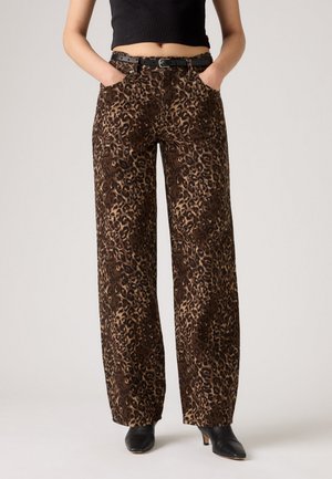 Pantaloni a cavallo largo con stampa leopardata in marrone e beige, dotati di tasche frontali, una cintura e una texture morbida. Tagliati per un fit rilassato.
