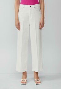 Pantalons blancs à jambes larges en tissu structuré, avec une taille haute, des poches avant et une fermeture à un bouton.