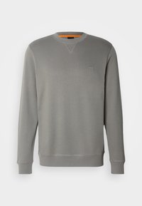 Sweat-shirt gris à manches longues avec col rond, poignets et ourlet côtelés, et un petit logo carré sur la poitrine.