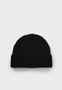 Căciulă tricotată neagră, cu o textură înălțată și o margine pliată. Prezintă modele discrete de tricot cu cabluri pe corpul principal.