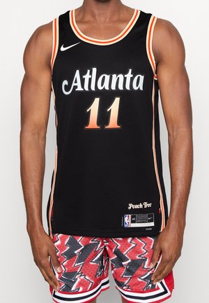 Maglia da basket nera con "Atlanta" in bianco e "11" in arancione. Presenta il marchio Nike. Abbinata a pantaloni corti rossi con motivo zigzag nero.