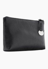 Pochette en cuir noir avec une texture lisse, de forme rectangulaire, fermeture éclair et une étiquette ronde en métal avec le nom de la marque.