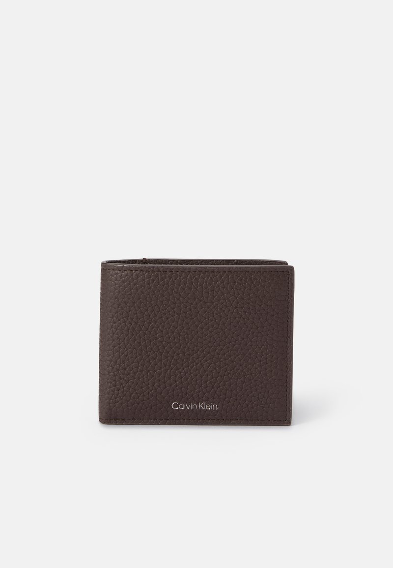 Hnedá textúrovaná kožená peňaženka s kompaktným dizajnom, na prednej strane so subtilným strieborným logom Calvin Klein. Zaoblené okraje.