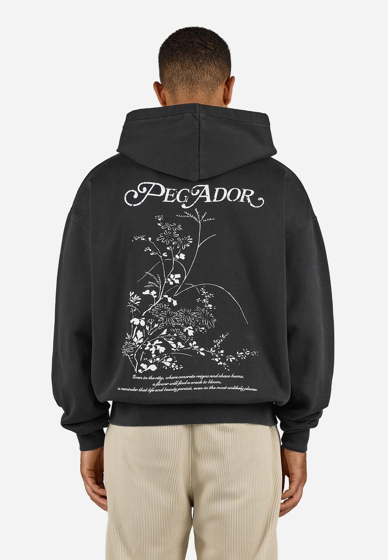 Sort oversized hoodie med et hvidt blomsterdesign og tekst på ryggen. Blødt, struktureret stof med en hætte med snor og ribbede manchetter.