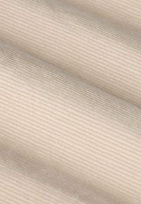 Beige textiel met een subtiele horizontale ribbelstructuur. Zacht materiaal vouwt in elegante golven, waardoor het gladde oppervlak wordt benadrukt.