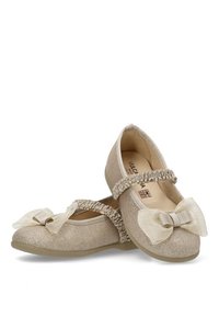 Bailarinas doradas con brillo, de punta redonda, tiras con volantes y un gran lazo en cada zapato. Parte superior texturizada y suave interior.