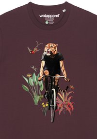 Bordeaux T-shirt met een fietser met een tijgerhoofd, omringd door levendige bloemen en bladeren, bedrukt in gedetailleerde kleuren en texturen.