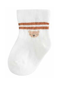 Calzino bianco in cotone con texture a coste, caratterizzato da una fascia marrone a strisce e un design di faccia d'orso al centro, che mette in risalto i suoi dettagli giocosi.