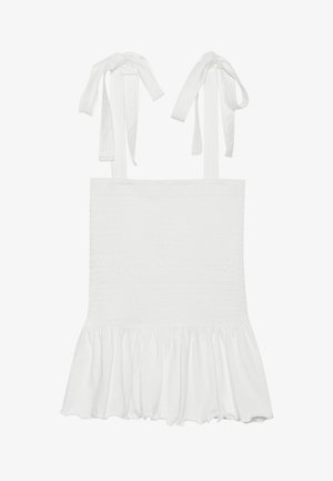 Débardeur smocké blanc avec ourlet volé, doté de liens ajustables sur les bretelles. Texture lisse et tissu léger.