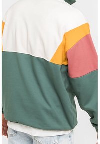 Giacca a blocchi di colore con pannelli verdi, bianchi, gialli e rosa. Realizzata in tessuto morbido con vestibilità rilassata e polsini a coste.