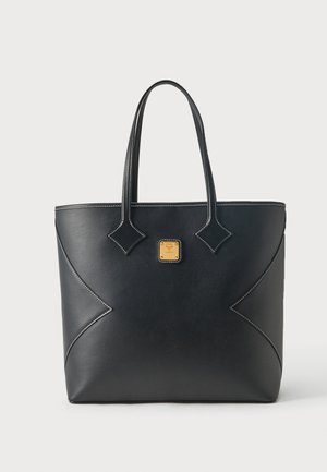 Sac fourre-tout en cuir noir avec double anses, couture contrastante blanche et une petite plaque logo carrée en or centrée sur le devant.