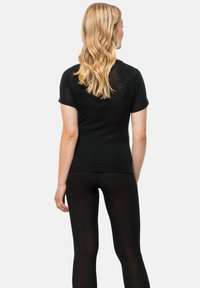 Zwart kort mouwen top en zwarte leggings gemaakt van zacht, rekbaar materiaal, met een strakke pasvorm en een gladde, lichte textuur.