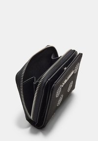 Portafoglio in pelle nera con un esterno strutturato, zip argentata e decorazioni circolari. Dispone di diversi scomparti per l'organizzazione.