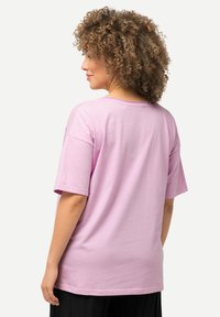 Lyserød bomulds t-shirt med korte ærmer, rund hals og en afslappet pasform. Glat tekstur uden synlige mønstre eller accenter.