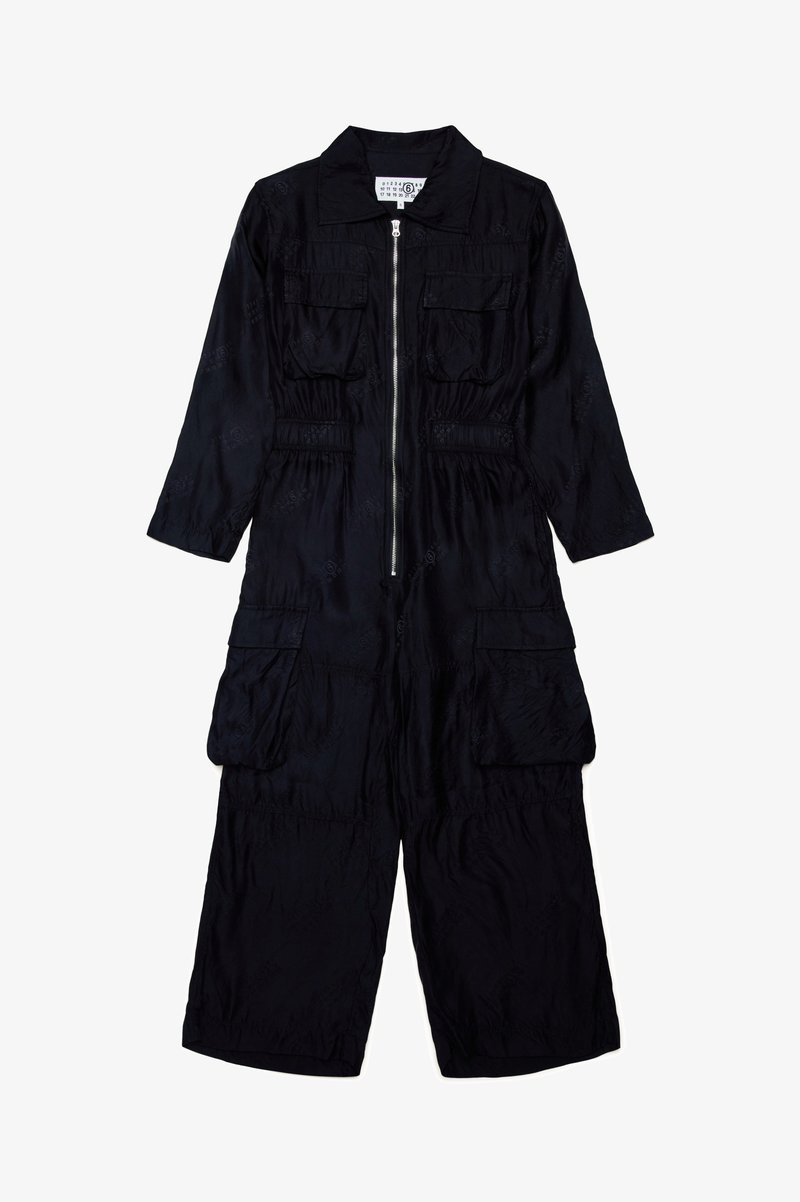 Monos de color negro con cuello, mangas largas y cremallera frontal. Presenta dos bolsillos en el pecho y dos bolsillos de carga inferiores. Tejido texturizado.
