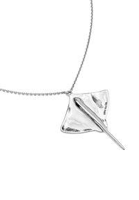 Collar de plata con un colgante de mantarraya que tiene una superficie pulida, cola alargada y forma de ala texturizada.