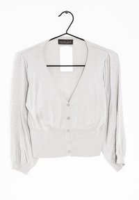 Ljusgrå kort cardigan i mjukt stickat material. V-ringning, puffärmar och fem knappstängningar framtill.