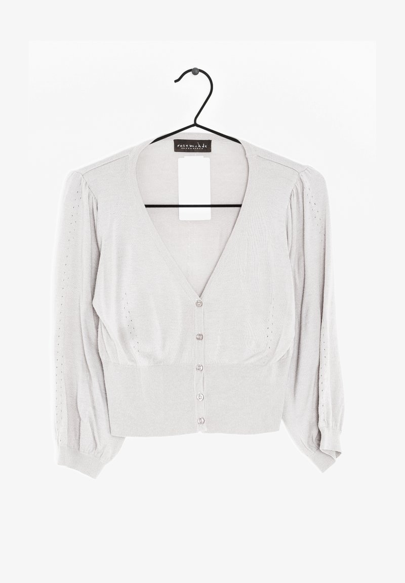 Ljusgrå kort cardigan i mjukt stickat material. V-ringning, puffärmar och fem knappstängningar framtill.